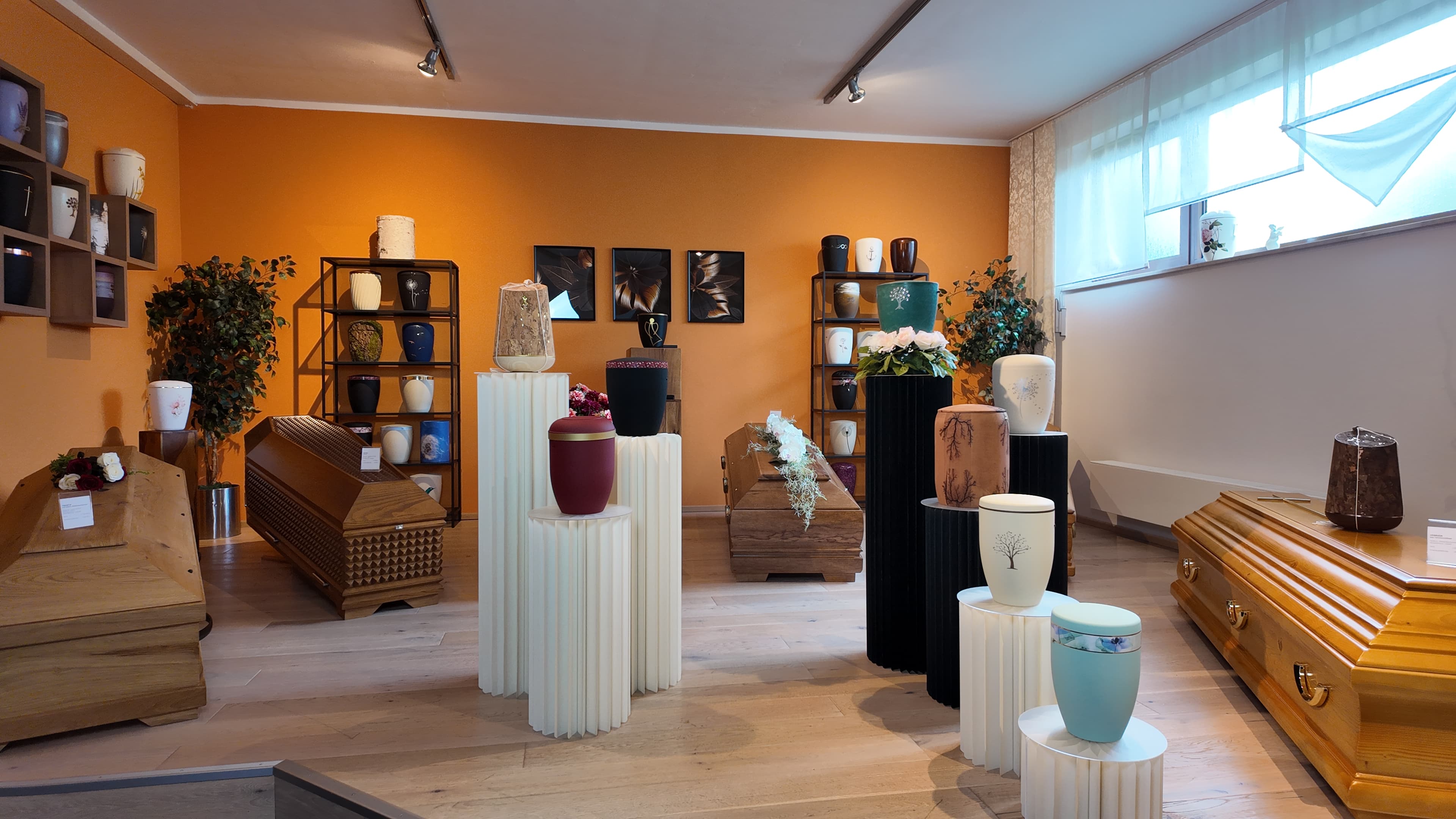 Verschiedene Särge und Urnen im Ausstellungsraum