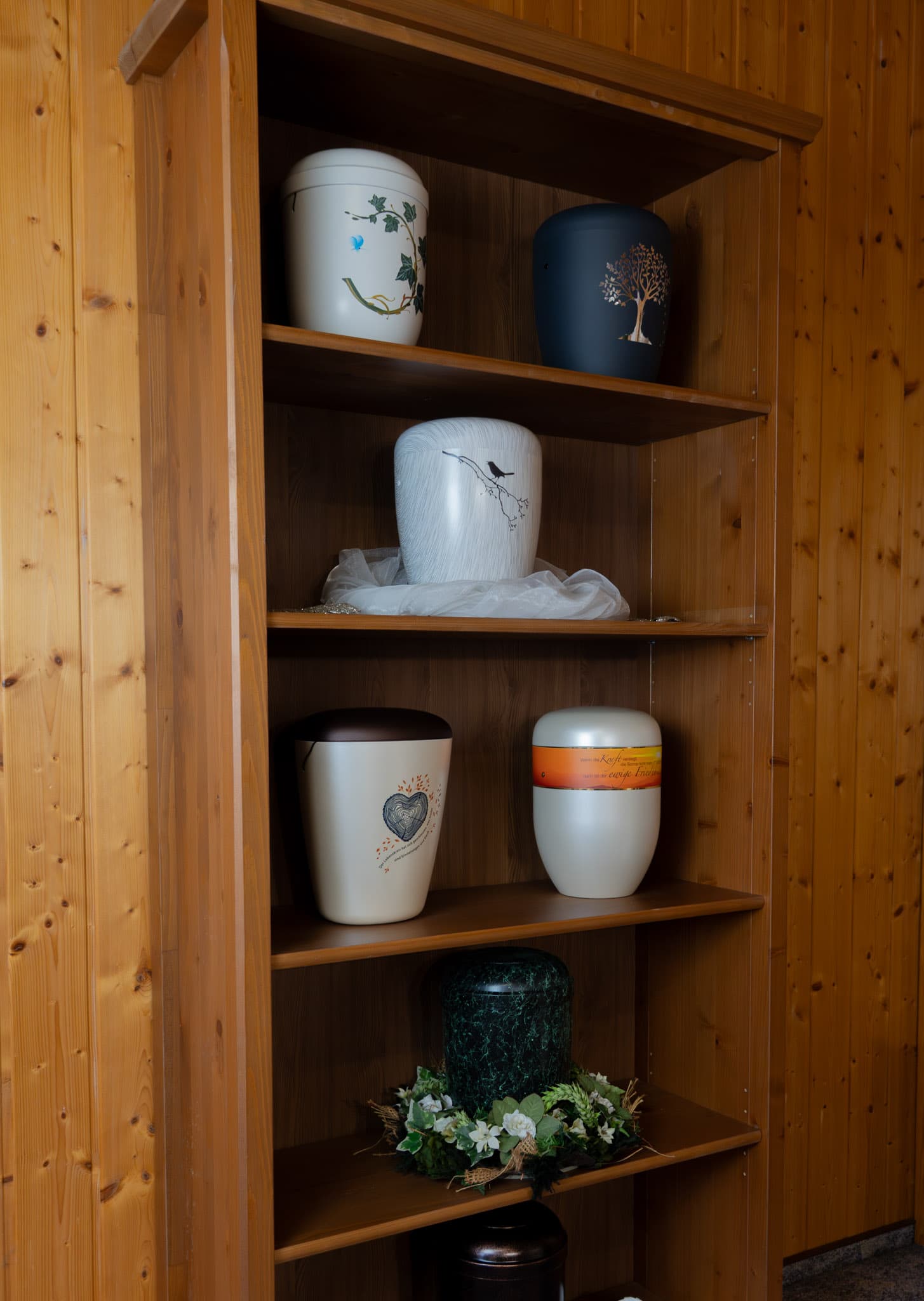 Verschiedene Urnen in einem Schrank
