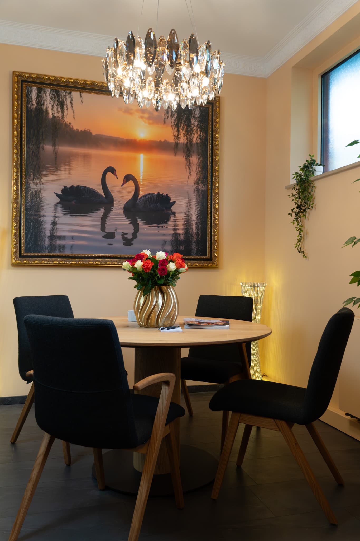 Tisch mit Stühlen und großem Gemälde
