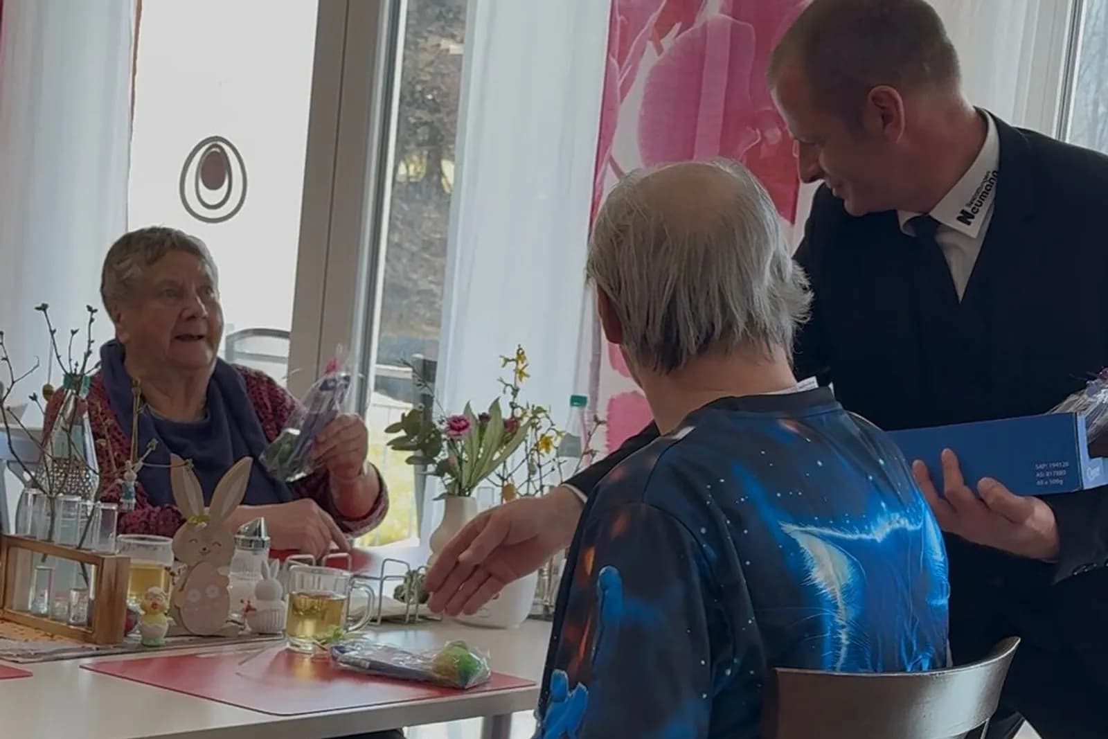 Mitarbeiter überreicht Ostergeschenk am Tisch